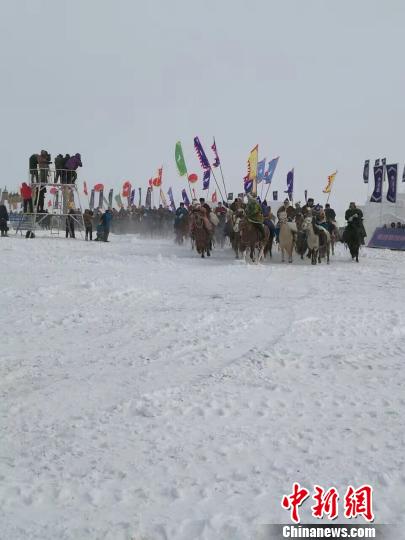 图为冰雪那达慕开幕式现场。活动开始时略有飘雪，天空也阴了，但人们热情高涨。　朱琳 摄