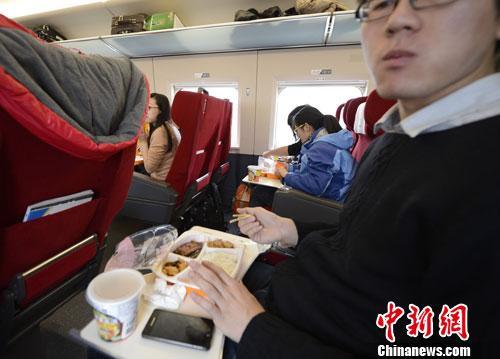 资料图:图为动车组乘客在品尝列车提供的餐食。<a target='_blank' href='http://www.chinanews.com/' _fcksavedurl='http://www.chinanews.com/'></table>中新社</a>发 侯宇 摄
